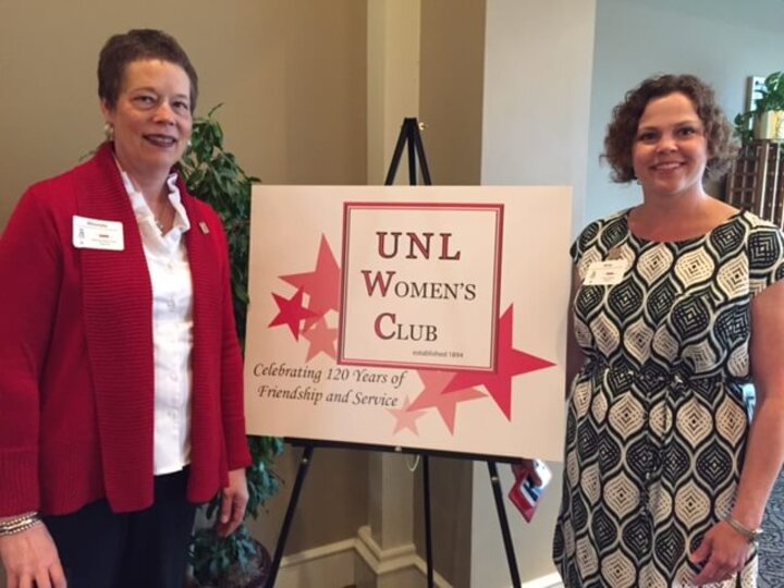 Two club members flank UNL Women's Club sign