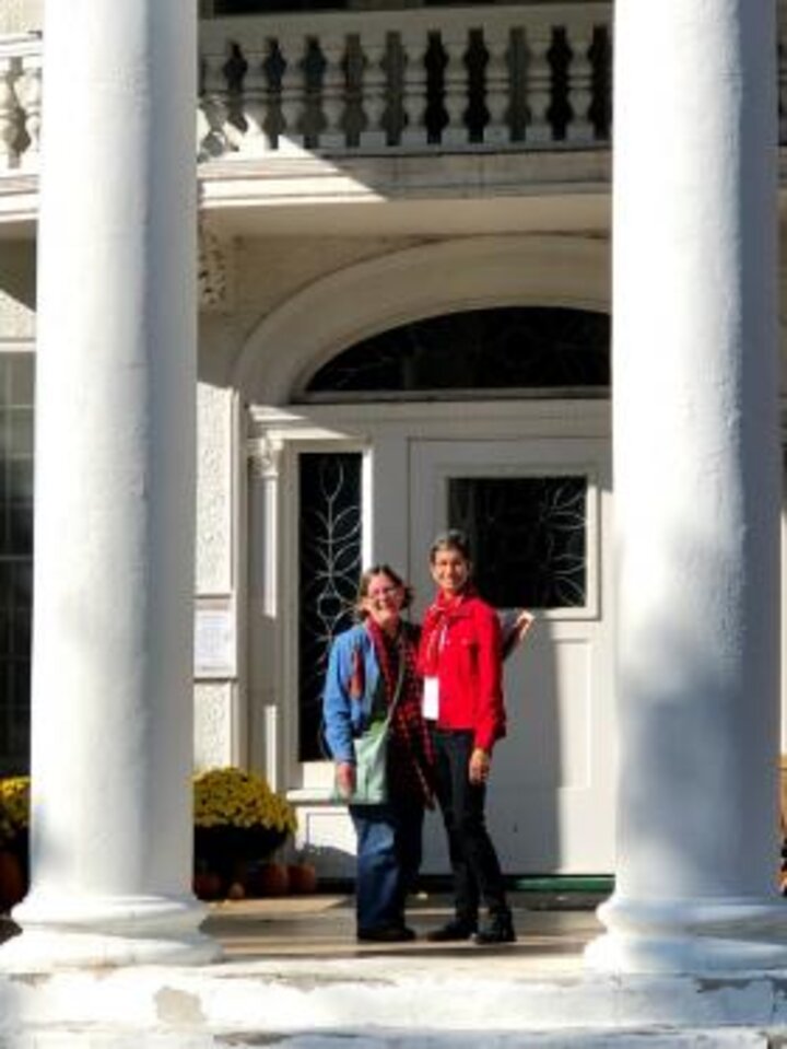Two women pose between columns at Arbor Lodge