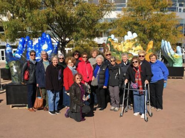 Club members standing in front of Serving Hands Lincoln sculptures.