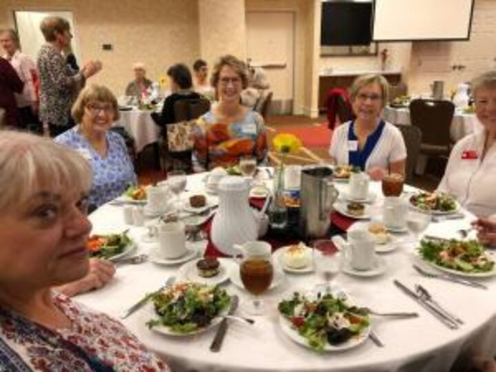 Club members seated at table eating food