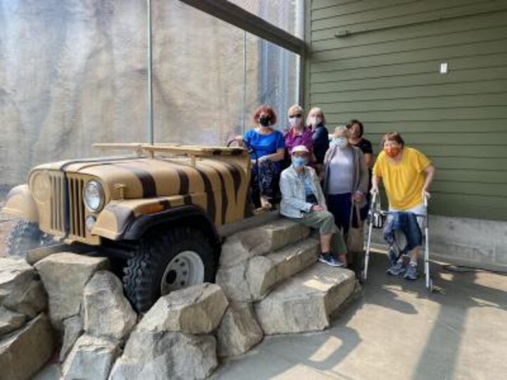 Club members pose on Jeep installation at Children's Zoo