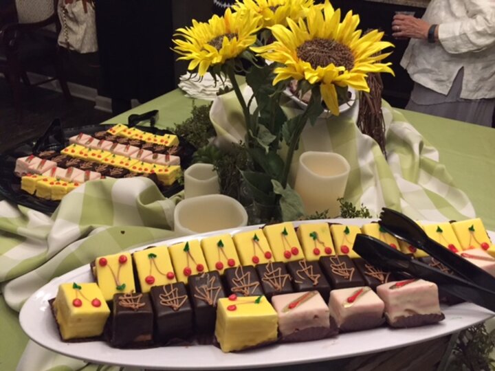 Large plates of piece of cake on table with sunflower and candle centerpieces.