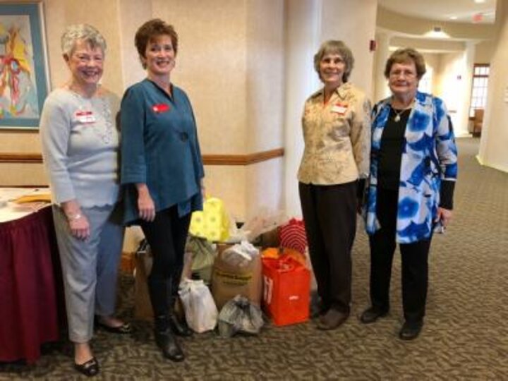 Club members flank pile of donations for Husker Helping Huskers Pantry.