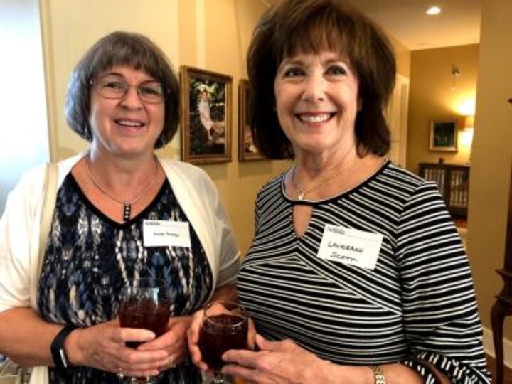 Two women holding drink pose for photo at Hank and Susie Bounds home.