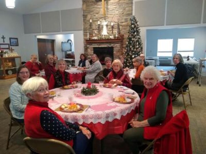 Club members sit at tables with meals.
