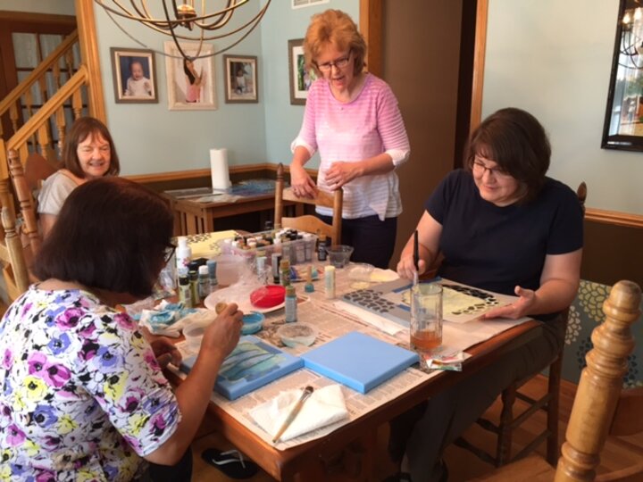 Four women working on painting crafts.