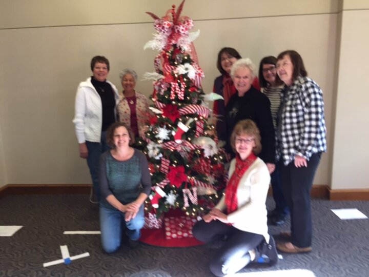 Club members flank decorated Christmas tree.