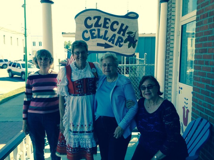 Four members stand in front of Czech Cellar sign.