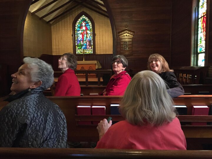 Women looking up inside a meager church.