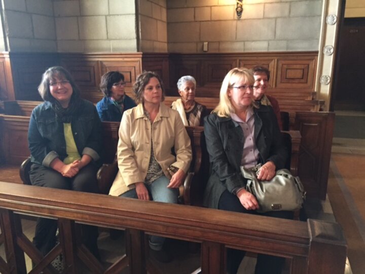 Three women sitting in pew.