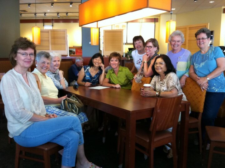 Club members sit at table at restaurant. 